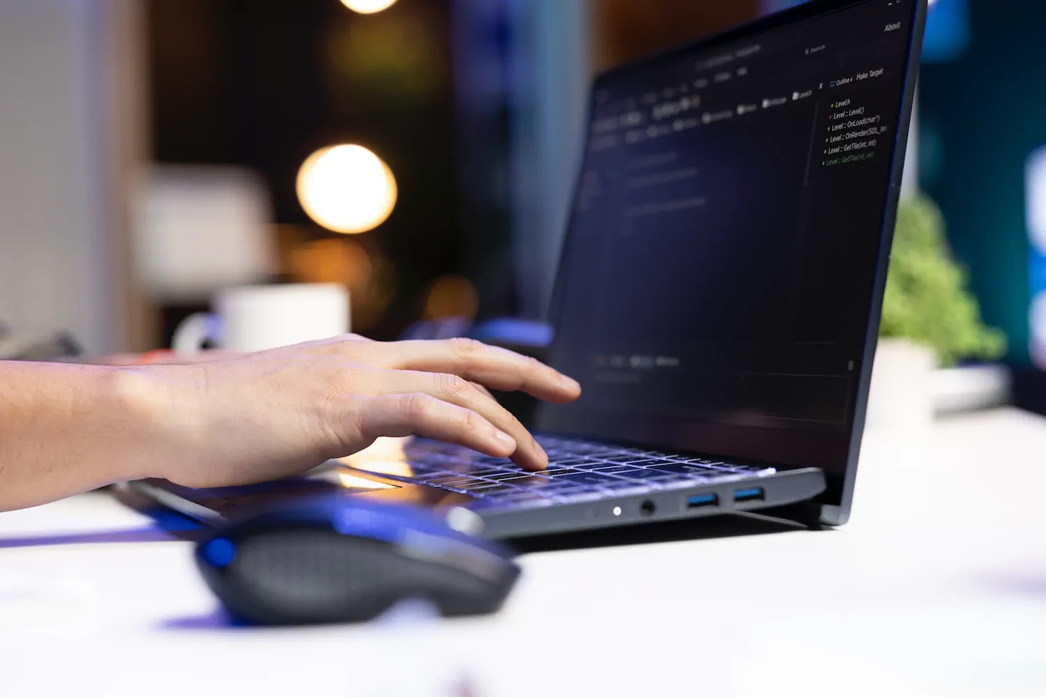 Programador trabajando en código desde laptop, enfocándose en seguridad web y prevención de ataques.