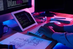 Tablet con planos de diseño web junto a computadora con código en pantalla