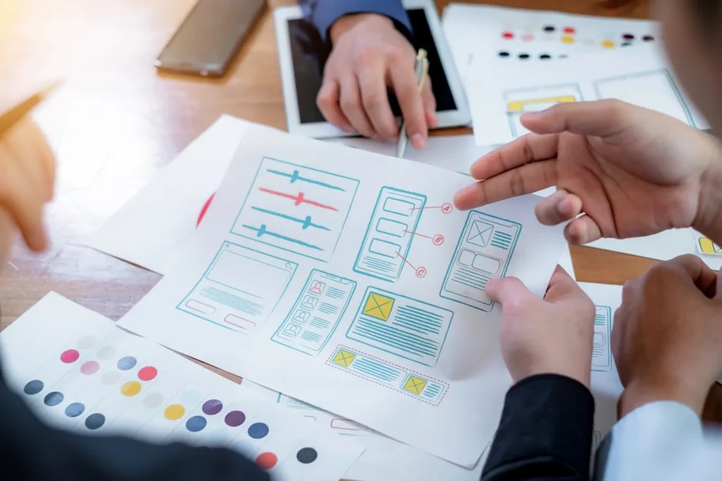 Team reviewing printed user experience prototypes.