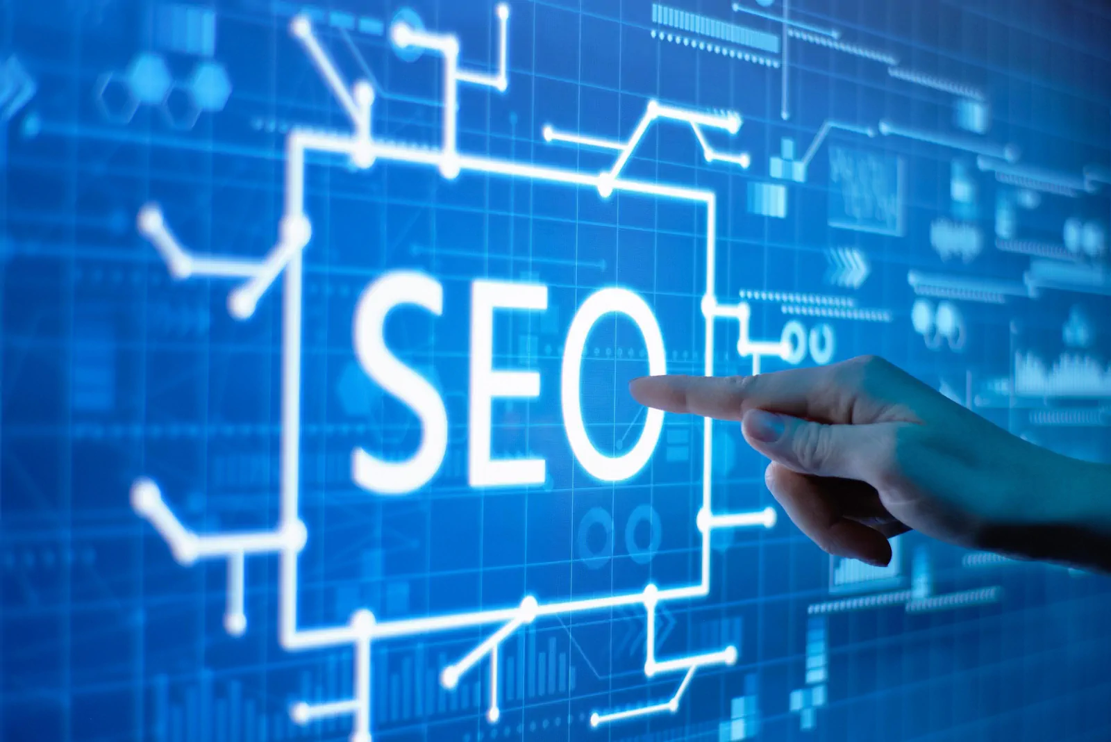 Pantalla digital con la palabra SEO y fondo tecnológico azul.