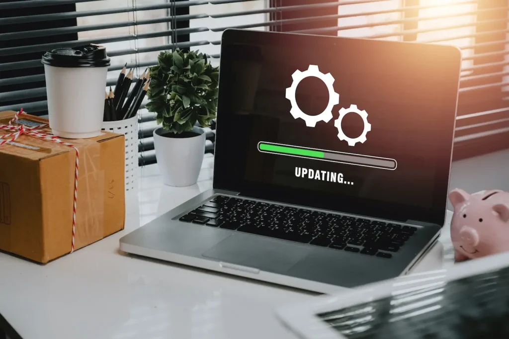 Laptop con engranes y barra de actualización, representando mantenimiento y actualización segura para evitar WordPress lento.