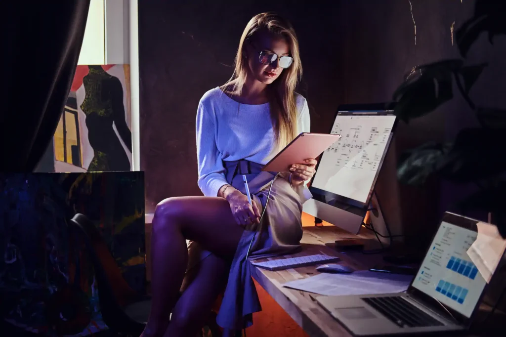 Woman working with a tablet and computer in an office