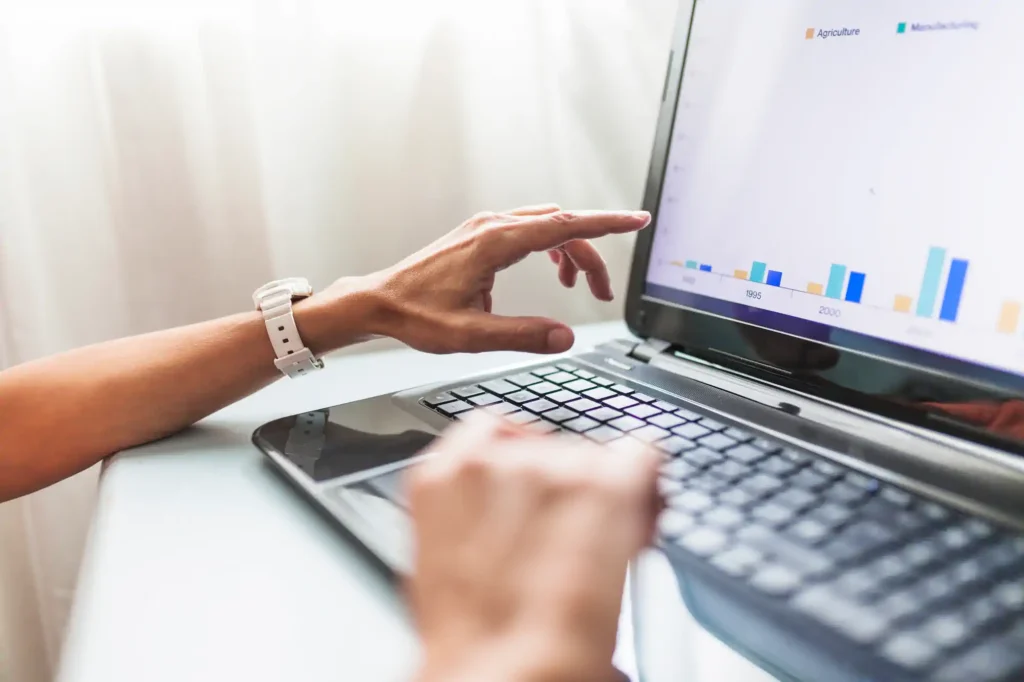 Person analyzing data charts on a laptop