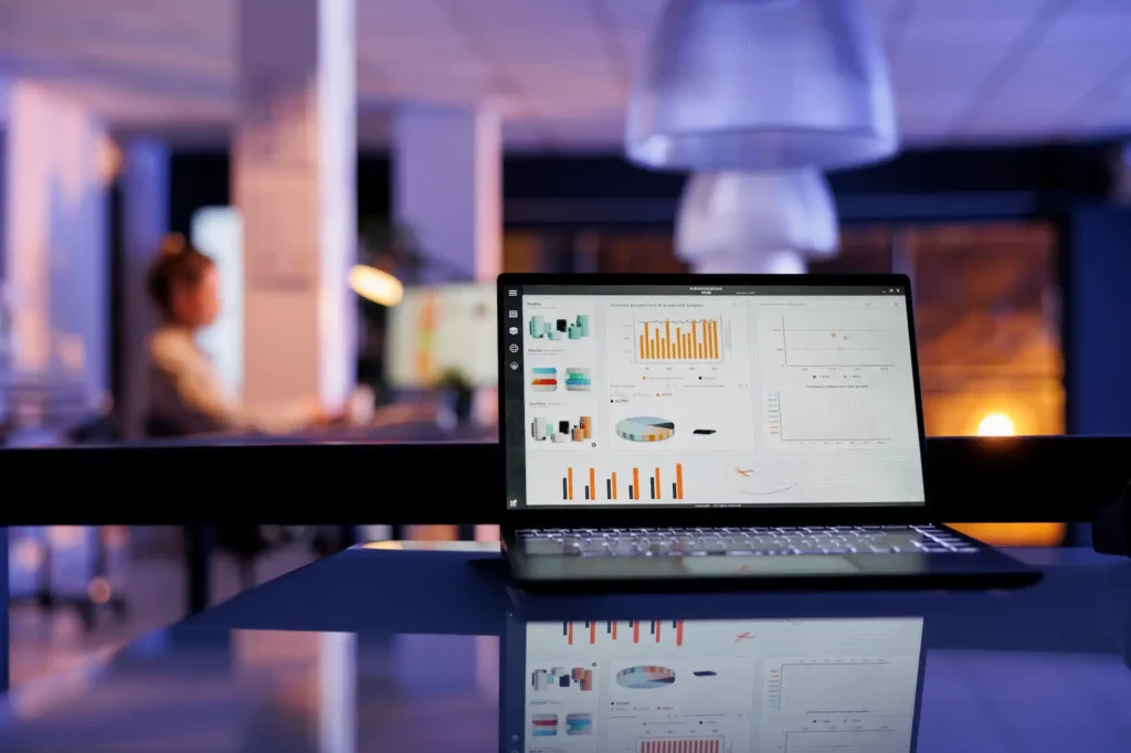 Laptop displaying financial charts in a modern office